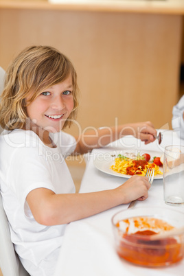 Side view of smiling boy at the dinner table