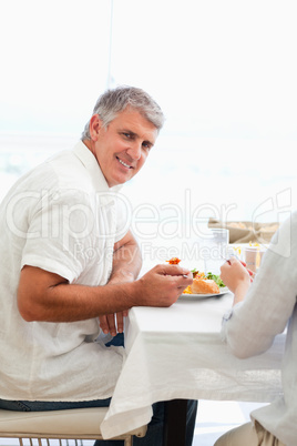 Side view of smiling man having dinner