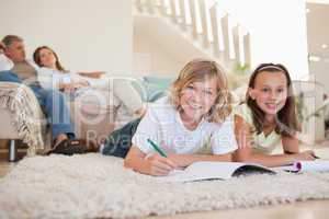 Brother and sister doing homework on the floor