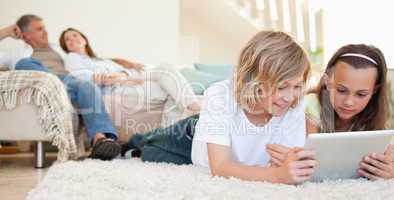 Siblings with tablet on the floor