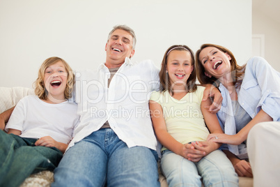 Laughing family sitting on the sofa