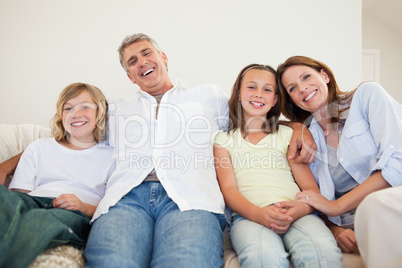 Laughing family sitting on the couch
