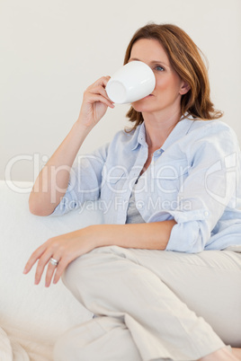 Woman drinking coffee on sofa