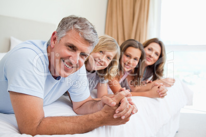 Smiling family lying on the bed