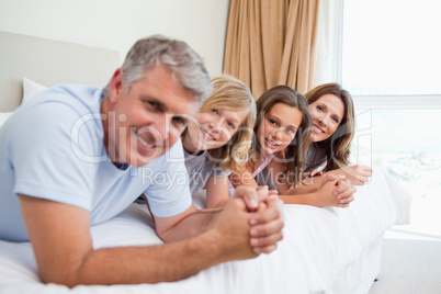 Happy family lying on the bed