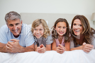 Smiling family laying on the bed