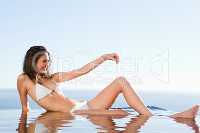 Woman sunbathing on pool edge