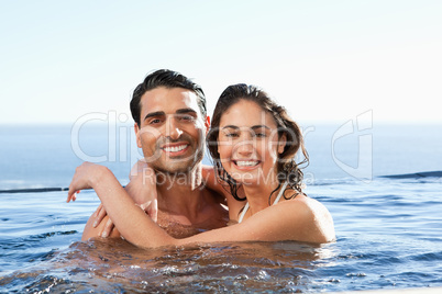 Smiling couple embracing in the pool