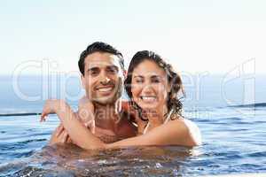 Smiling couple embracing in the pool