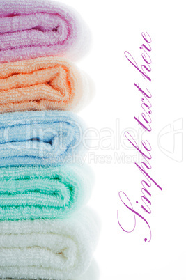 multicolor towels stacked on white background with area for your