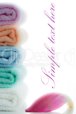 multicolor towels stacked with a lotus petal on white background