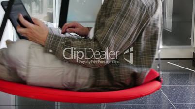 Male - Working with Notebook and Mobile in Swinging Seat