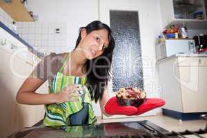 Frau mit einem Kuchen aus dem Inneren eines Ofens
