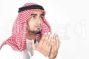 Young arab man of muslim religion praying isolated on white background