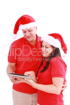 Happy Christmas couple looking a tablet computer. Isolated on wh