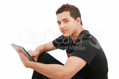 A smiling man sitting on the floor with a tablet, isolated on wh