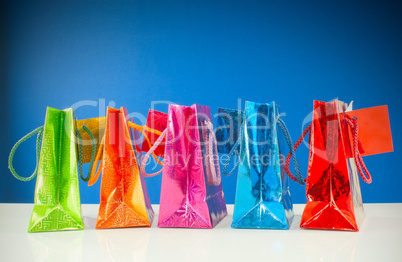 Row of colorful bags against blue background