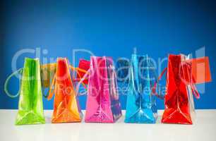 Row of colorful bags against blue background
