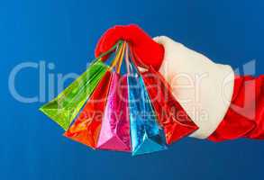 Santa's hand holding colorful bags