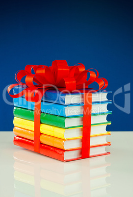 Stack of colorful books tied up with red ribbon