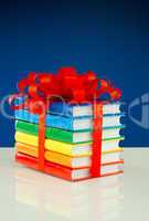 Stack of colorful books tied up with red ribbon