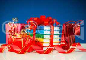 Christmas presents with stack of books against blue background