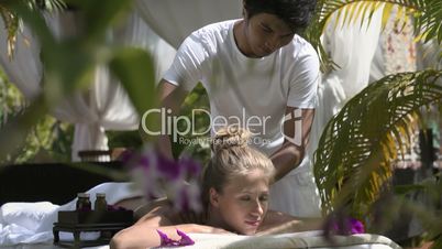 Masseur at work massaging young beautiful woman in exclusive resort