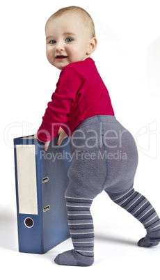 small child standing next to blue ring binder