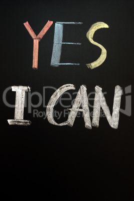 Chalk handwriting of "YES I CAN" on a blackboard