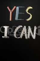 Chalk handwriting of "YES I CAN" on a blackboard
