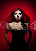 Serious woman in day of the dead mask on red