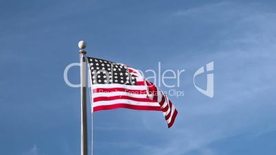 USA flag flying on the wind on blue sky background