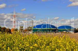 Biogasanlage am Rapsfeld mit Strommasten - Grüne Energie