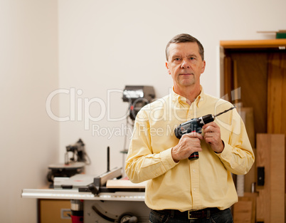 Senior man holding power drill