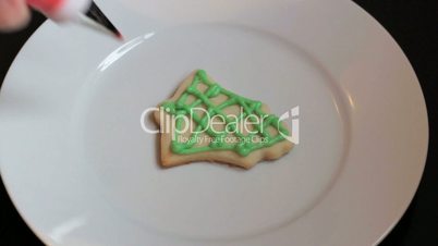 Adding Red Icing To Bell Shaped Christmas Cookie