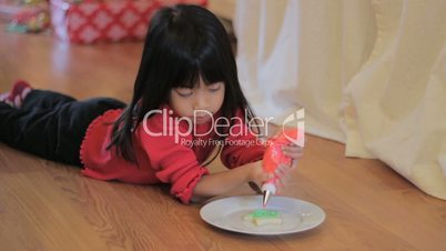 Girl Decorating Christmas Cookie With Red Icing
