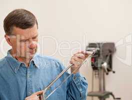 Senior man holding a metal saw