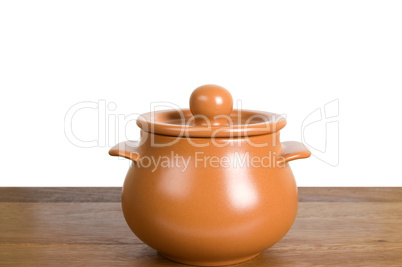 Kitchen clay pot on the wooden board
