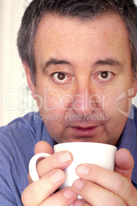 Mann trinkt aus Tasse