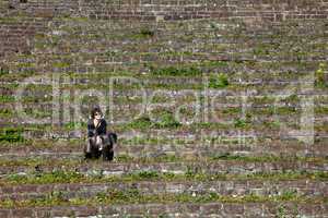 Frau sitzt allein auf Steintreppe