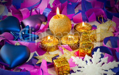 Christmas decorations and candles over blue background