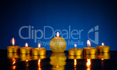 Seven burning candles over blue background