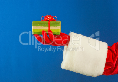 Santa's hand holding a present over blue background