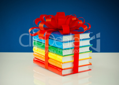 Stack of colorful books tied up with red ribbon