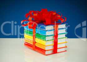Stack of colorful books tied up with red ribbon