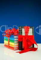 Books tied up with ribbon and electronic book reader against blue background