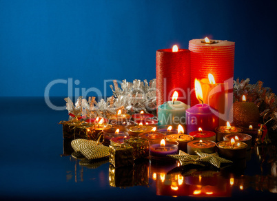 A lot of burning colorful candles against dark blue background