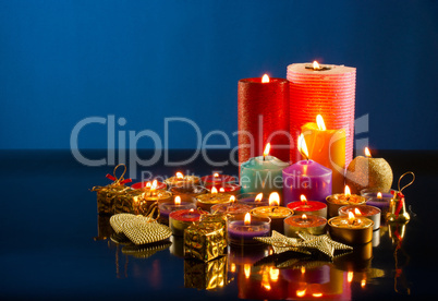 A lot of burning colorful candles against dark blue background