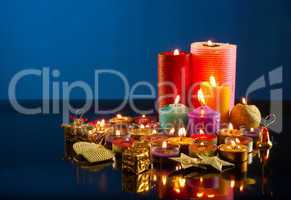 A lot of burning colorful candles against dark blue background