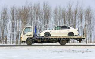 The wrecker carries the car of white color